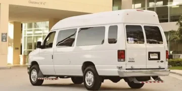 Beli kombi parkiran ispred ulaza zgrade