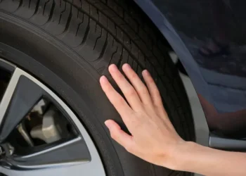 Koncept bezbednosti u automobilizmu – ruka na automobilskoj gumi