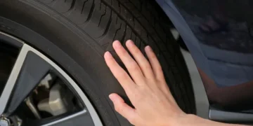 Koncept bezbednosti u automobilizmu – ruka na automobilskoj gumi